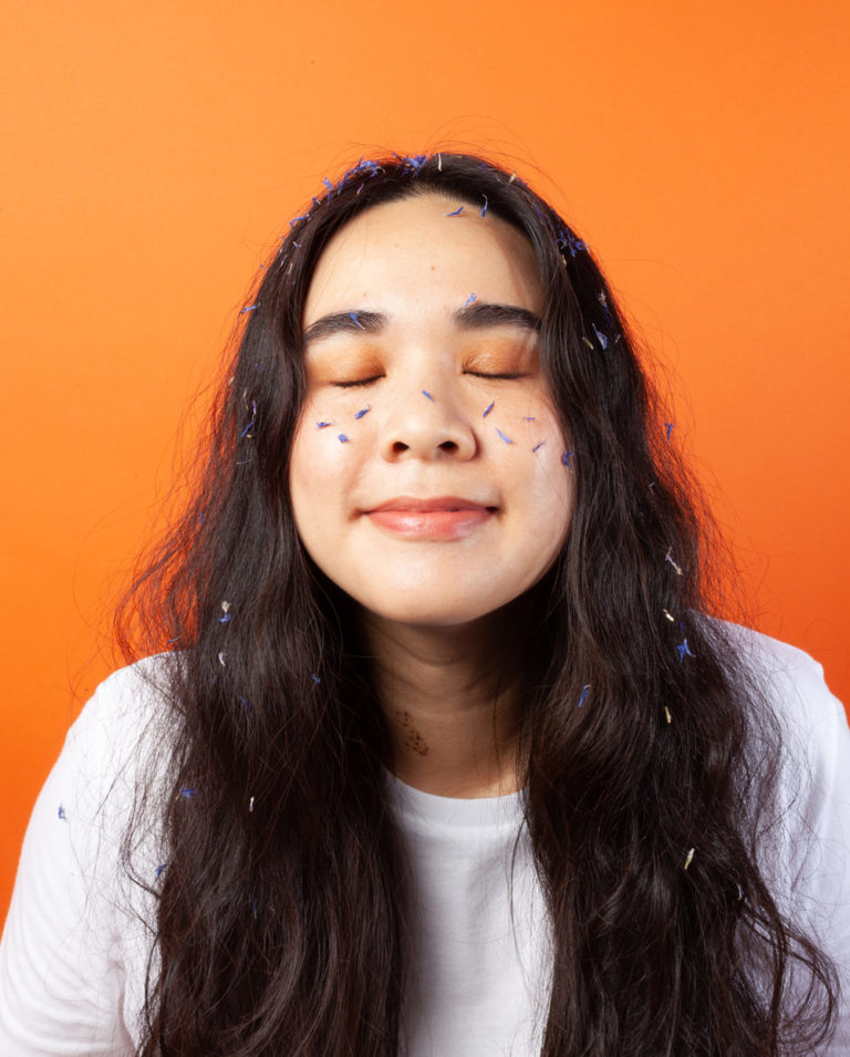 Femme asiatique avec des extraits de plantes sur son visage